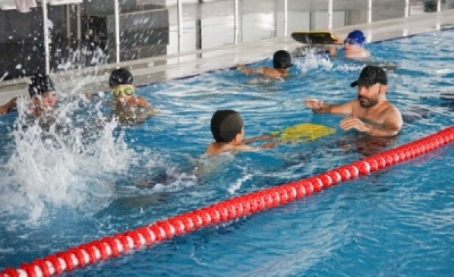 Karaköprü'de çocuklar hem yüzmeyi öğreniyor hem de serinliyor